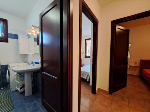 カステルサルドにあるCasa Marina di Castelsardoのバスルーム(シンク付)、部屋へ続くドアが備わります。