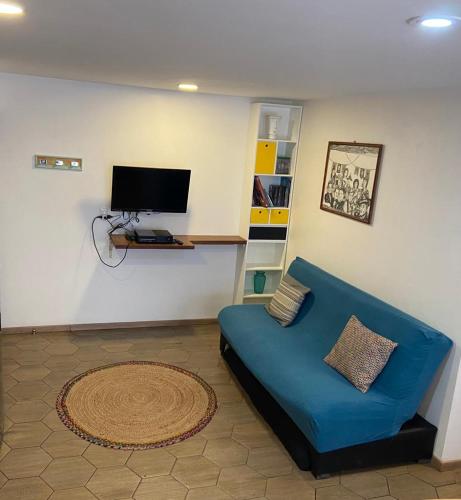 a living room with a blue couch and a tv at CENTRAL APARTMENT IN THE HEART OF MEXICO CITY in Mexico City