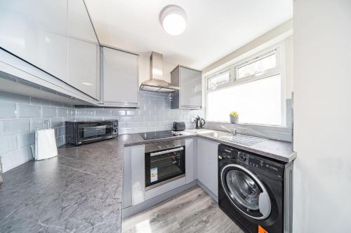a kitchen with a washer and a dishwasher at Hosted By Ryan - Huge 4 Bedroom House in Liverpool