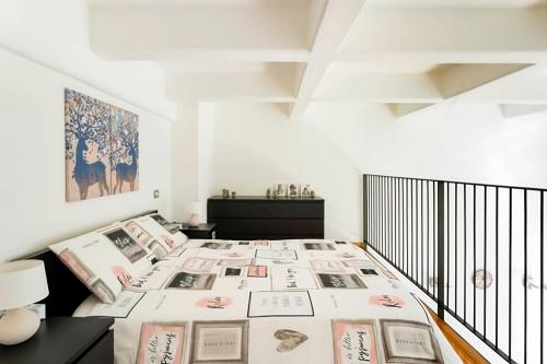 una camera bianca con un letto con delle foto sopra di Luxury Loft a Milano - Design esclusivo e comfort moderno a Milano