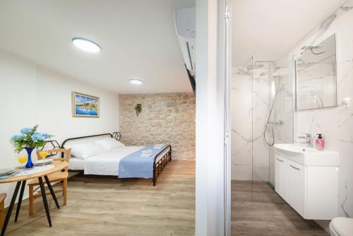 a bedroom with a bed and a bathroom at Apartments Jerolim in Split