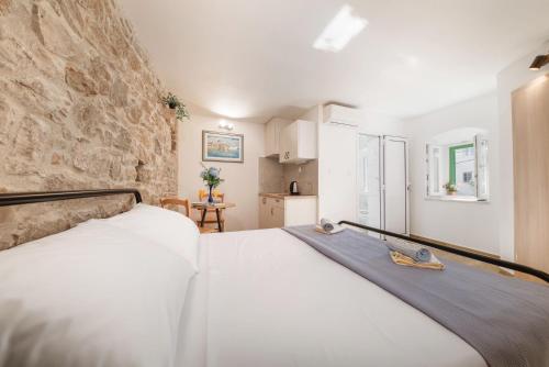 a bedroom with a bed and a stone wall at Apartments Jerolim in Split