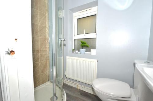 a white bathroom with a toilet and a shower at 2 Beds House in City Center in Birmingham