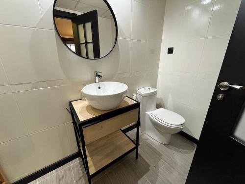 a bathroom with a sink and a toilet and a mirror at El rincón de Martín en Huesca in Huesca