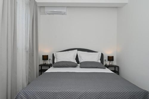 a bedroom with a large bed with two pillows at Romantic Escape With Private Hot Tub Near Split in Žrnovnica