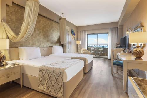 a hotel room with two beds and a desk at Spice Hotel & Spa - Ultra All Inclusive in Belek