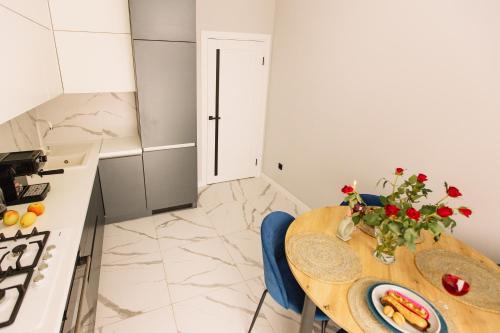a kitchen with a wooden table and blue chairs at ENERGIE Дизайнерська стильна квартира в новому ЖК in Ternopilʼ