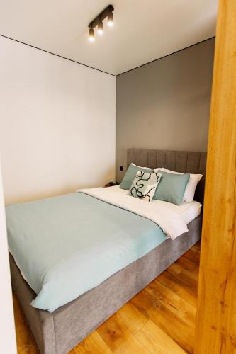 a bedroom with a large bed with green pillows at ENERGIE Дизайнерська стильна квартира в новому ЖК in Ternopilʼ