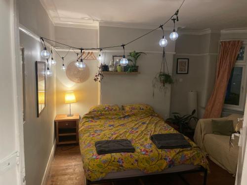 a bedroom with a bed and a couch and lights at Birchfields Party House in Manchester