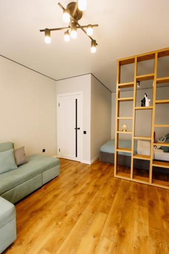 a living room with a couch and a book shelf at ENERGIE Дизайнерська стильна квартира в новому ЖК in Ternopilʼ