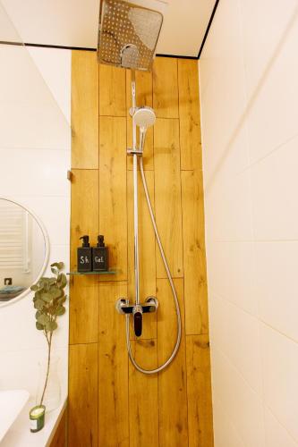 a shower in a bathroom with a wooden wall at ENERGIE Дизайнерська стильна квартира в новому ЖК in Ternopilʼ