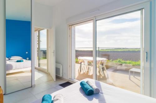 een slaapkamer met een bed en uitzicht op de oceaan bij Charmante maison vue sur mer proche Carnac in Plouharnel