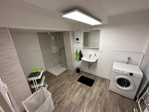 een badkamer met een wasmachine en een wastafel bij Ferienwohnung mit separaten Eingang - Mola in Wetter