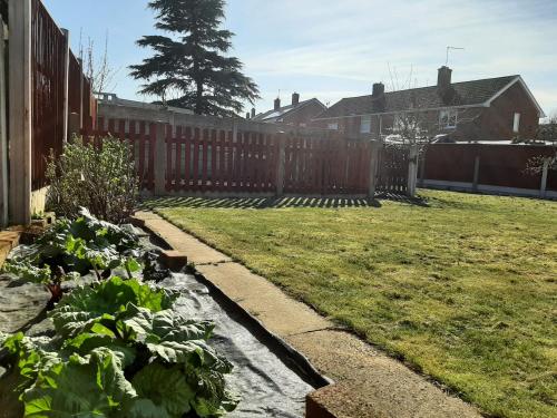 a backyard with a fence and a garden with plants at Huge Garden House for Contractors and Families in Ollerton