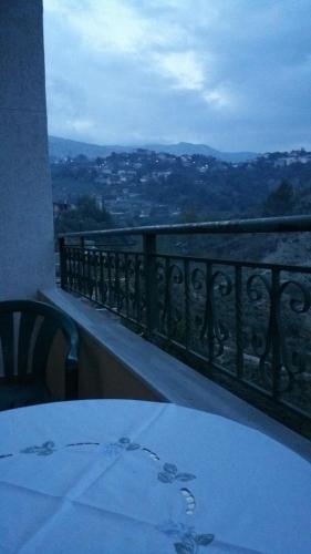 a table and chairs on a balcony with a view at GuestHouseMantho in Gjirokastër