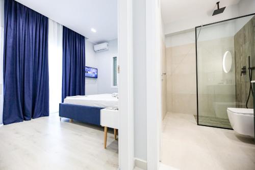 a bedroom with a bed and a bathroom with a tub at Villa Luisanna Free Parking in Vlorë