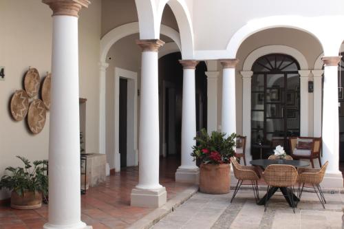 a courtyard with columns and a table and chairs at Casa Angeles Mascota in Mascota