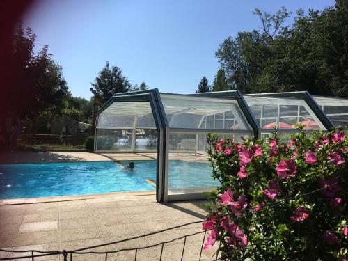 uma grande casa de vidro com piscina em Camping le Relais du Léman em Messery
