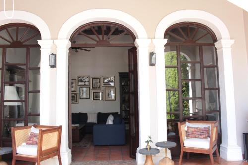 a living room with two arched doors and chairs at Casa Angeles Mascota in Mascota