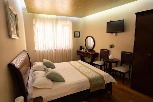 - une chambre avec un lit, une coiffeuse et un miroir dans l'établissement Scallop Regent Rooms, à Zadar