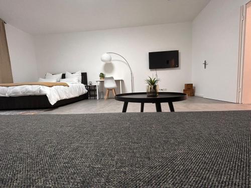 um quarto com uma cama, uma mesa e uma televisão em Europa Apartments nähe Düsseldorf Messe, Airport em Krefeld