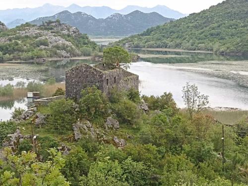 an old building on a hill next to a river at Feel the Karuch in Cetinje