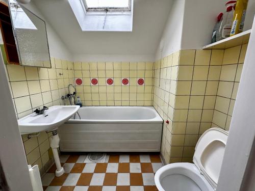 een badkamer met een bad, een wastafel en een toilet bij Ljungaverk Atelje Takvåning med Takfönster Ekgolv Charmigt in Ljungaverk