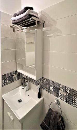 une salle de bain avec un lavabo et un miroir dans l'établissement studio au cœur Montmartre, à Paris