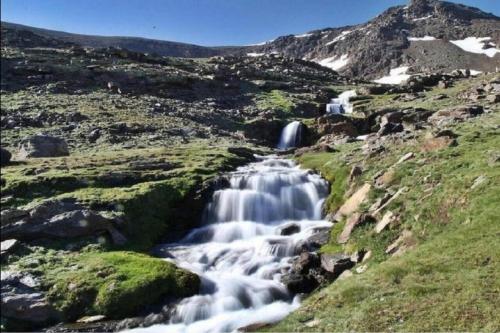 a group of waterfalls in a field with a mountain at TODOSIERRANEVADA ZONA BAJA - MONTBLANC VISTAS A LA MONTANA - Junto a los Telecabinas in Sierra Nevada