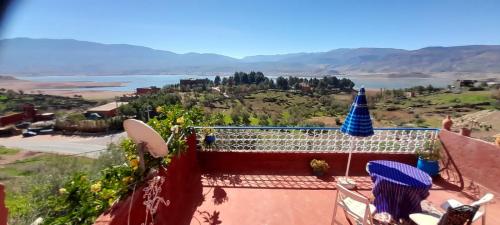 a woman sitting on the roof of a house with a view at Abla room in Azilal