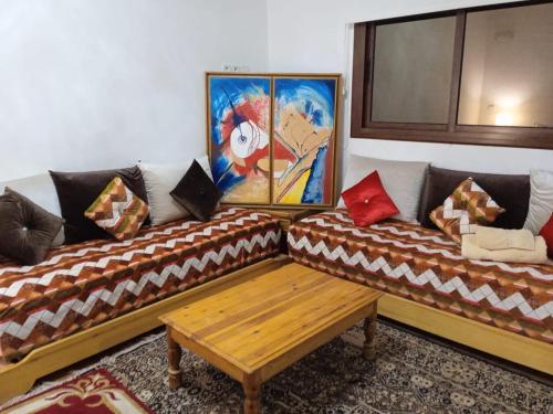 un soggiorno con 2 divani e un tavolo in legno di Abla room ad Azilal