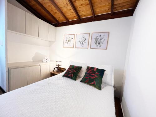 a bedroom with a white bed with two pillows at Villas Alto Bonito in Sevilla