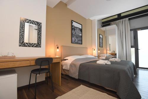 a hotel room with two beds and a desk at Il Padrino Rooms in Zadar