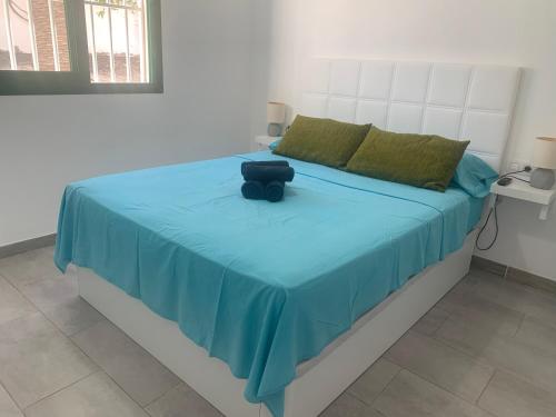 een slaapkamer met een bed met een blauw dekbed bij La Perla de S.Valentin in Corralejo