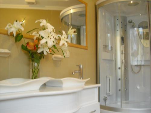 a bathroom with a sink and a vase of flowers at Hotel G&G in Cuenca