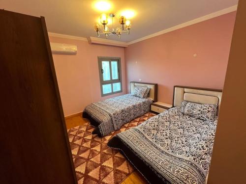 شقه ٣ غرف على البحر فى سبورتنج في الإسكندرية: غرفة نوم بها سريرين وثريا