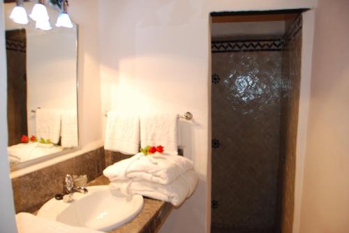 ein Badezimmer mit einem Waschbecken und einer Dusche mit Handtüchern in der Unterkunft Dar Al Batoul in Fès