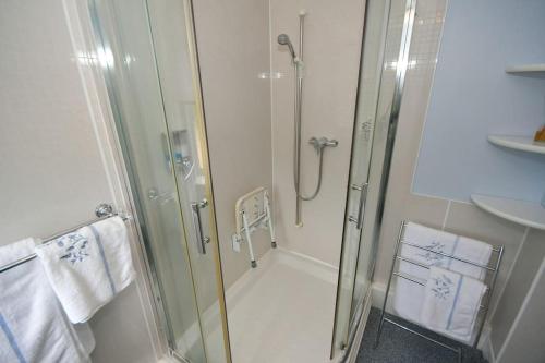 a shower in a bathroom with a glass shower backdoor at Little Hare Lodge - Spacious 2 bedroom attached bungalow in Woodhall Spa
