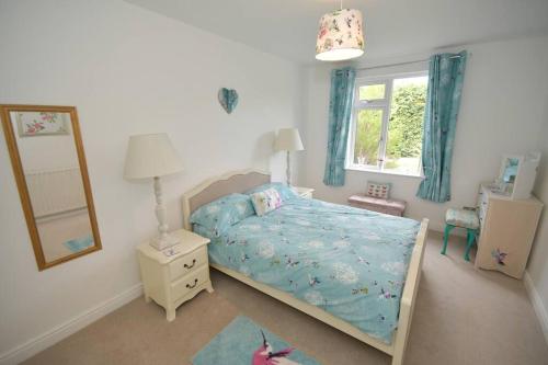 ein kleines Schlafzimmer mit einem Bett und einem Spiegel in der Unterkunft Little Hare Lodge - Spacious 2 bedroom attached bungalow in Woodhall Spa