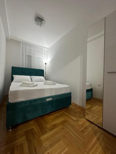 - une chambre avec un lit doté d'une tête de lit verte et d'un miroir dans l'établissement Port 3, à Belgrade