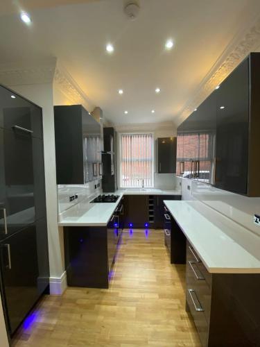 a large kitchen with white counter tops and black cabinets at Luxury Apartment with a jacuzzi in Wolverhampton