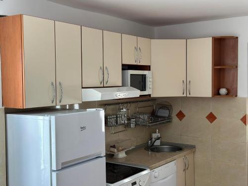 a kitchen with white cabinets and a white refrigerator at Apartman Emily in Nikšić
