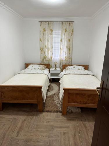 a bedroom with two beds and a window at Apartmani Emily & Jully in Nikšić