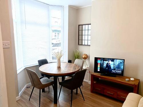 a dining room with a table and a television at Rosa House in Darlington