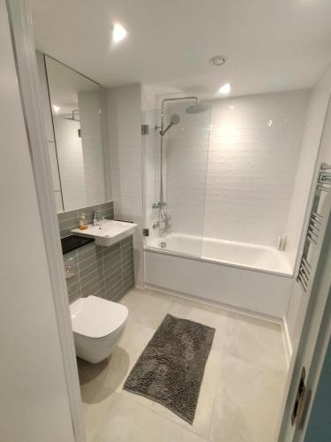 uma casa de banho com um WC, uma banheira e um lavatório. em Lovely Apartment with Free Parking One Bedroom 416 em Luton