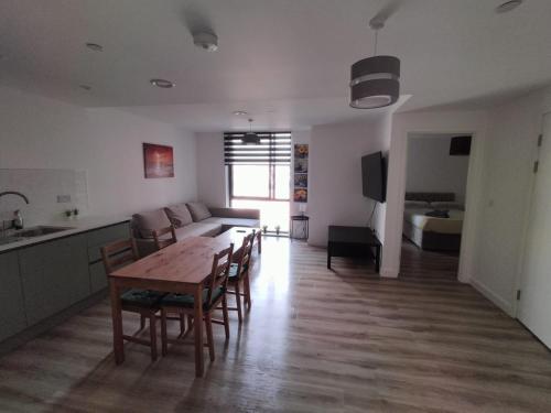 uma sala de estar com uma mesa e cadeiras e um sofá em Lovely Apartment with Free Parking One Bedroom 416 em Luton