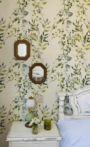 a bedroom with a wall with a floral wallpaper at Bodega Sibeiro in Chantada