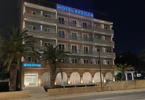 un hotel con palmeras frente a un edificio en Kreoli Hotel, en Atenas