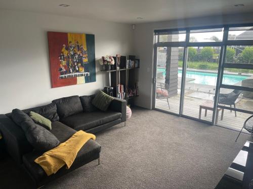 a living room with a couch and a pool at Titoki Grove in Cambridge