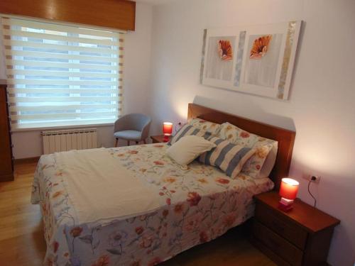 聖地亞哥－德孔波斯特拉的住宿－apartamento con jardin，一间卧室配有一张带两张蜡烛的床。
